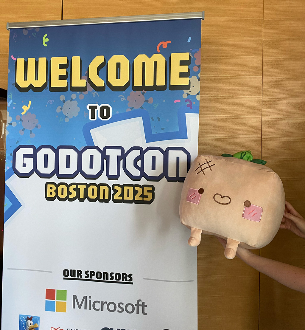 The Cubified Turnip Boy plush next to the Godotcon banner!